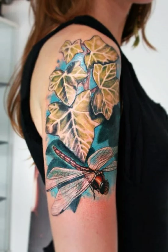 buntes Oberarm-Tattoo mit Efeublättern und Libellen 