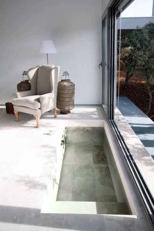 Eingelassene Badewanne einfaches Design jedoch sehr ansprechend Glasschiebewand zum Garten