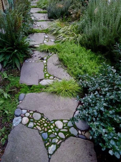 Gartenwege aus Stein Steinplatten mit kleinen Steinen Moos Gras dazwischen