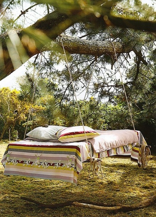 Hängebett draußen im Garten an einem Baum aufgehängt in Boho Stil wirkt einladend