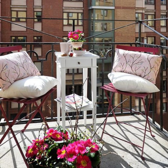 Sommerblumen Deko Ideen den Balkon dekorieren Blumen in Töpfen zwei Stühle hoher Tisch Kissen