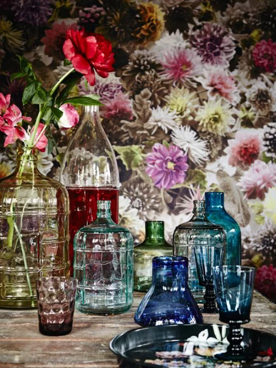 Sommerblumen Deko Ideen viele Vasen aus buntem Glas Blumen gemusterte Tapete