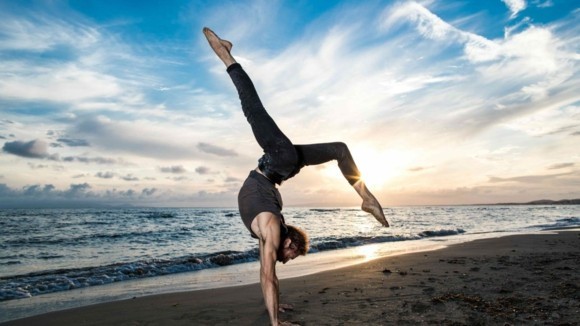 Yoga Sonnengruß Surya Namaskar am Strand beim Sonnenuntergang