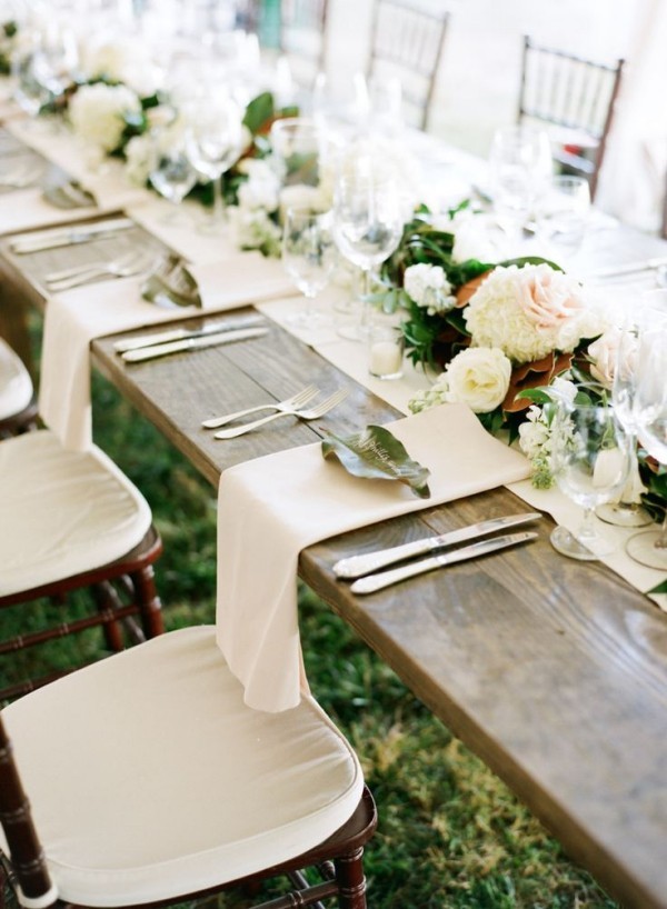 Hochzeitsdeko - weiße Servietten auf einem Holztisch