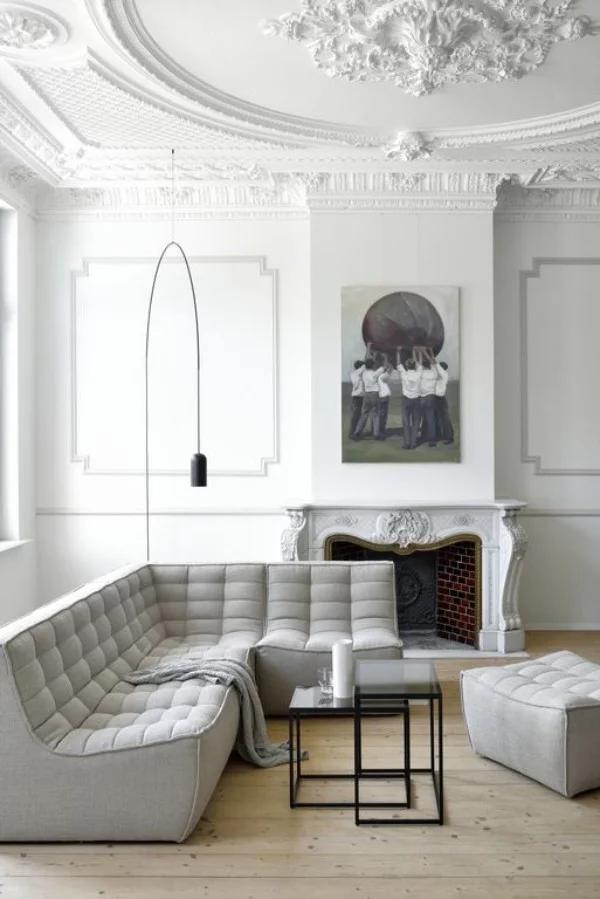 Pariser Chic im Wohnzimmer weißes Interieur Stehlampe Ecksofa verzierte Decke Rosette Bild Kamin