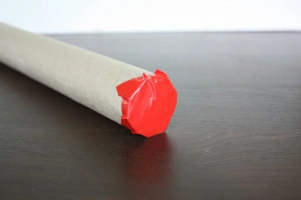 Regenmacher als Kinderspielzeug Öffnung schließen mit rotem Panzerband kleben