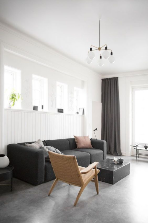 Wohnzimmer in Schwarz-Weiß beigefarbener Stuhl Kissen hohe Fenster grauer Boden Industrial Style Touches