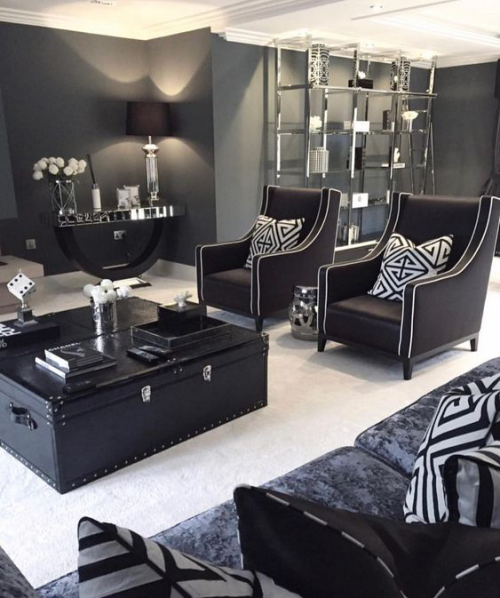 Wohnzimmer in Schwarz-Weiß imposante Raumgestaltung schicke Möbel alter Truhentisch fein gemusterte Kissen
