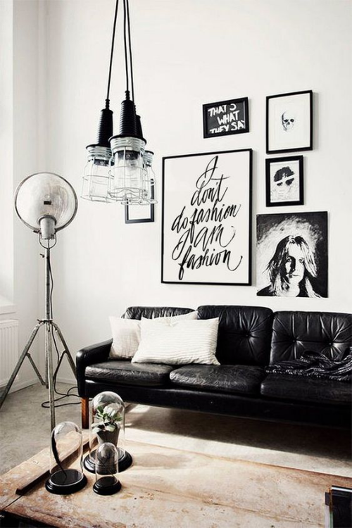 Wohnzimmer in Schwarz-Weiß moderne Raumgestaltung Wandbilder Ledersofa Stehlampe alter Holztisch Vintage