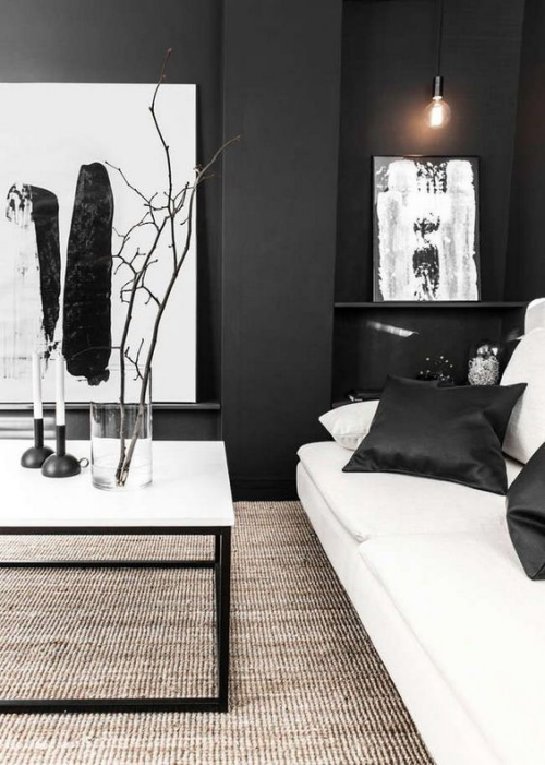 Wohnzimmer in Schwarz-Weiß schwarze Wände weißes Sofa schwarze Satin Kissen Deko Artikel Wandgemälde