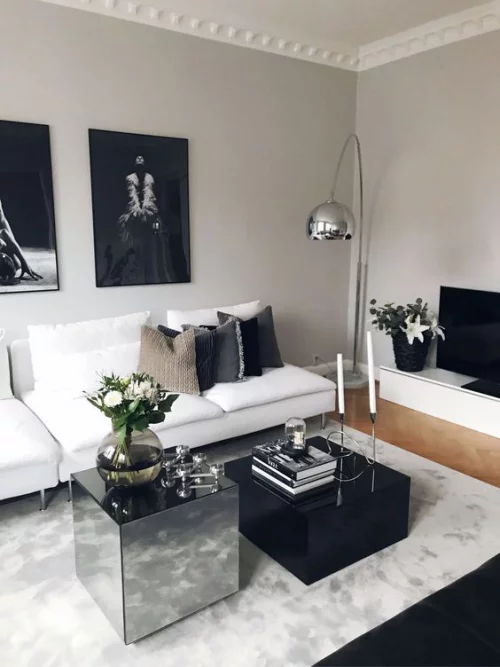 Wohnzimmer in Schwarz-Weiß viel Grau weißes Sofa etwas Silberglanz im Interieur