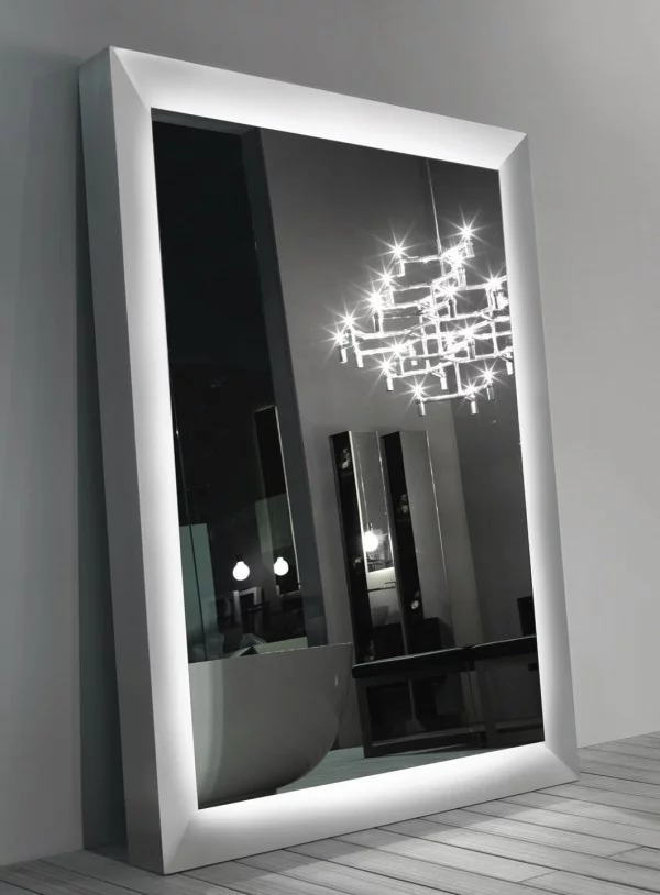 großer Spiegel im silbernen Rahmen reflektiert den Kronleuchter im Zimmer 