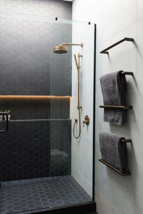 Fliesen-Akzente im Bad kreativ und gewagt hexagonale schwarze Fliese Duschkabine Glaswand graue Handtücher graue Wan