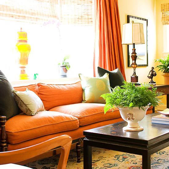 Herbstdeko im Wohnzimmer warm viel Tageslicht sehr gemütlich Sofa in Orange Grün Gelb