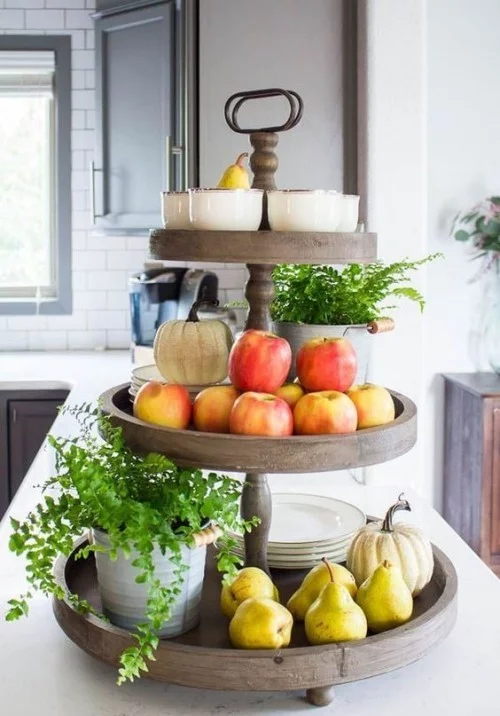 Herbstdeko in der Küche reiche Ernte Äpfel Birnen auf dem Holzständer Kürbisse Teller etwas Grün