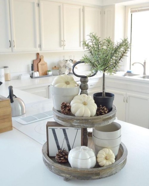 Herbstdeko in der Küche rustikales Arrangement weiße Kürbisse Tannenzapfen in einer modernen Küche