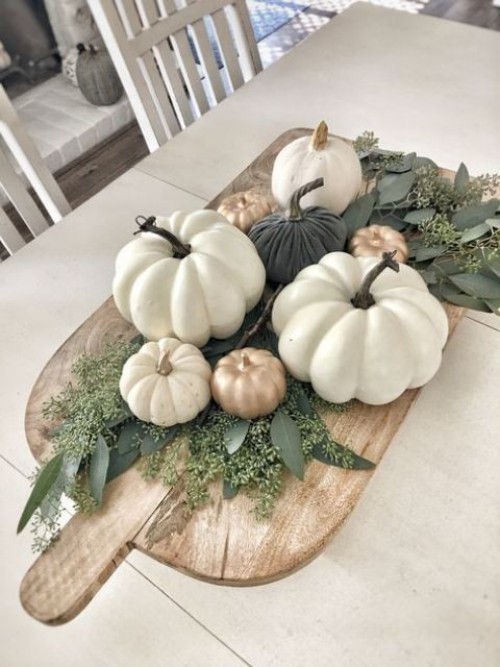 Herbstdeko in der Küche schönes Arrangement mit Kürbissen und Blättern auf Holzbrett