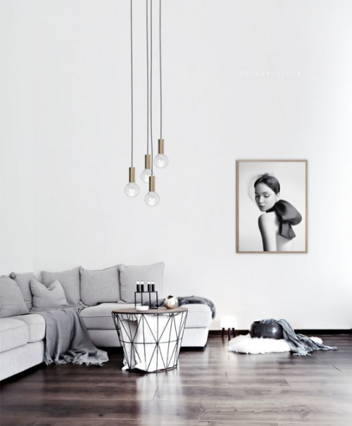 Minimalismus im Wohnzimmer Ecksofa kleiner Tisch Kerzen hängende Lampen Wandgemälde Ruhe und Einfachheit