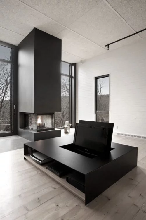 Minimalismus im Wohnzimmer perfektes Raumdesign Säule mit Bio Kamin viel Tageslicht Medientisch als Zentralstück