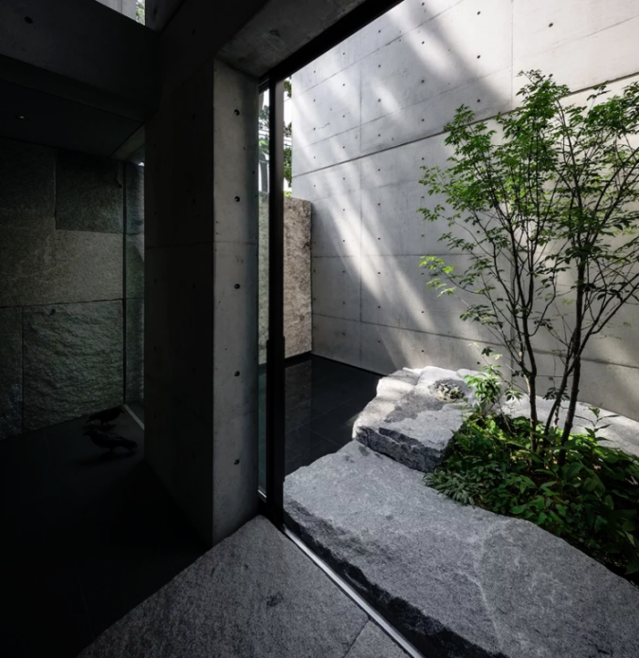 Minimalistisches Haus aus Stein und Beton in Japan Innenhof schwarze Fliesen Naturstein Glastüren Tageslicht