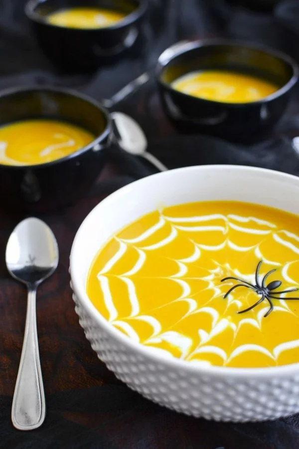 Halloween Snacks für Kinder gesunde Kürbissuppe mit Spinne und Netz