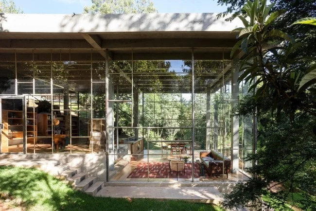 Modernes Haus aus Glas und Beton im Regenwald errichtet schreibt sich harmonisch in die Umgebung ein