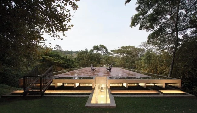 Modernes Haus aus Glas und Beton im Regenwald weite Dachterrasse mit wetterresistenten Holzbrettern verdeckt