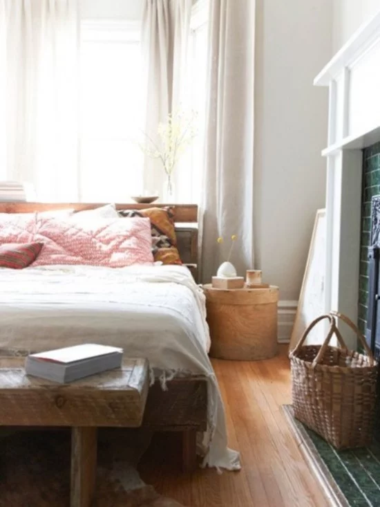 Schlafzimmer herbstlich gestalten Schlafbett rosa Kissen Sitzbank aus Holz Flechtkorb daneben