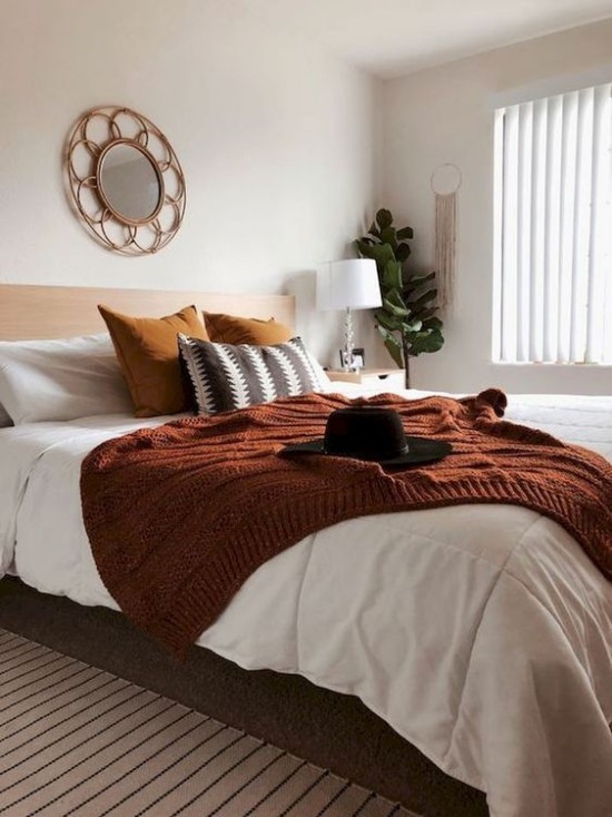 Schlafzimmer herbstlich gestalten gemütliche Atmosphäre Kontrast zwischen Weiß und Dunkelbraun schwarzer Filzhut grüne Zimmerpflanze Ecke