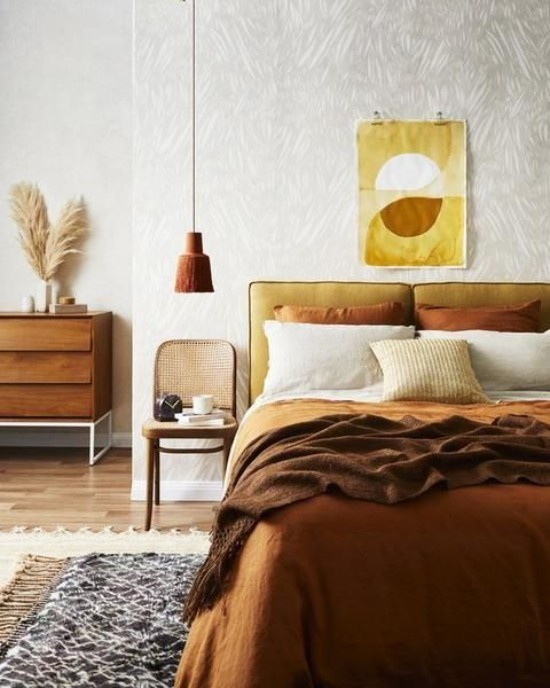 Schlafzimmer herbstlich gestalten gemütliche Atmosphäre Wanddeko Gelb Braun Bettzeug in Ocker und Schokoladenbraun