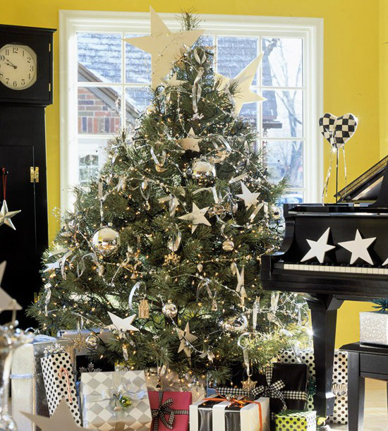 Weihnachtsbaum schmücken in Weiß und Silber klassischer Christbaum goldener Schmuck zahlreiche verpackte Geschenke neben dem Klavier