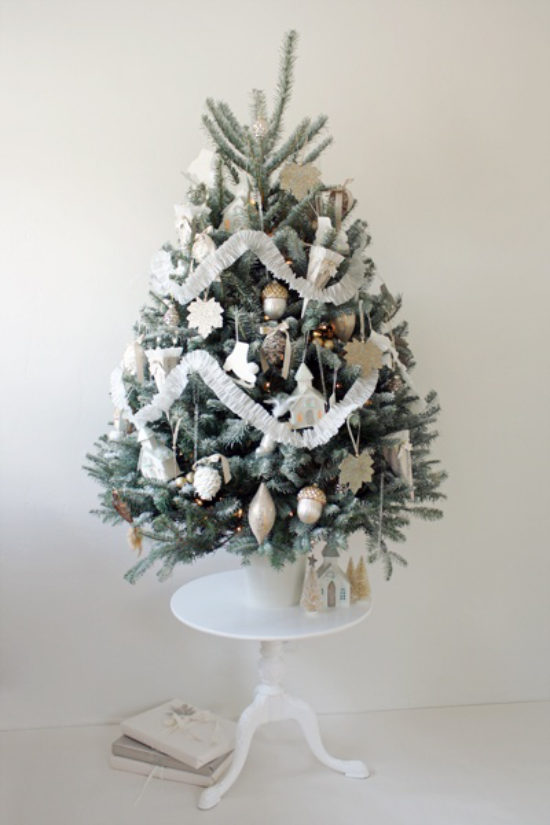 Weihnachtsbaum schmücken in Weiß und Silber kleiner Christbaum auf kleinem runden Tisch platziert schön dekoriert
