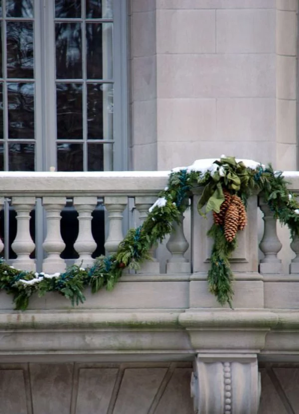 Weihnachtsdeko für Balkon - grüne Girlande am Balkongelände und Tannenzapfen