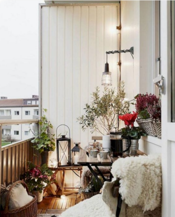 Weihnachtsdeko für Balkon verschiedene Topfpflanzen farbige Akzente setzen weiche Texturen weißer Pelz auf dem Stuhl viele Kerzen
