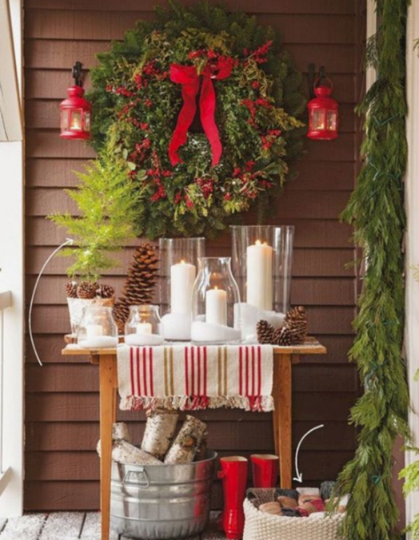 Weihnachtsdeko für Balkon viel Tannengrün rote Schleifen rote Stiefel weiße Kerzen gemütlich und ansprechend