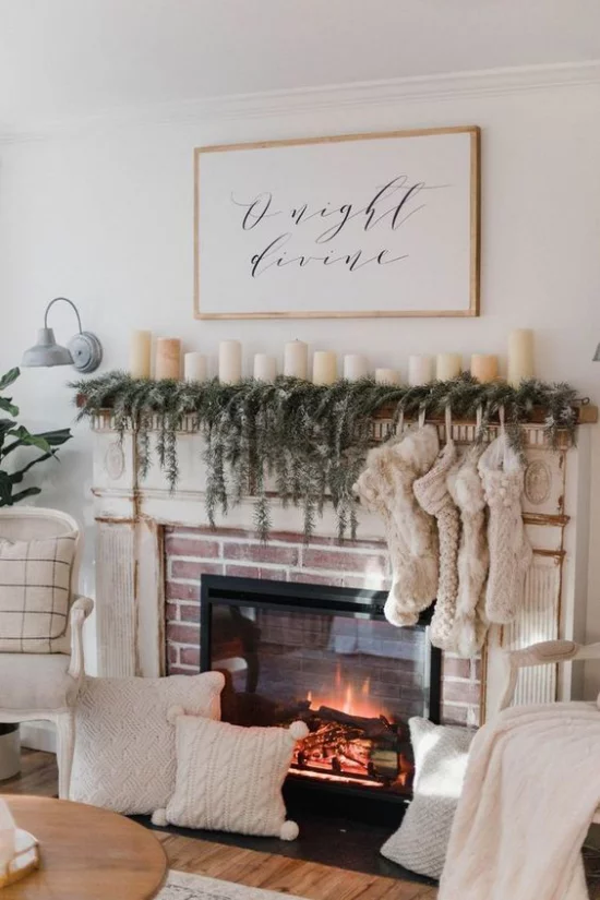 brennder Kamin - Nikolausstrümpfe, etwas Tannengrün, weiße Kerzen und weiße Kissen