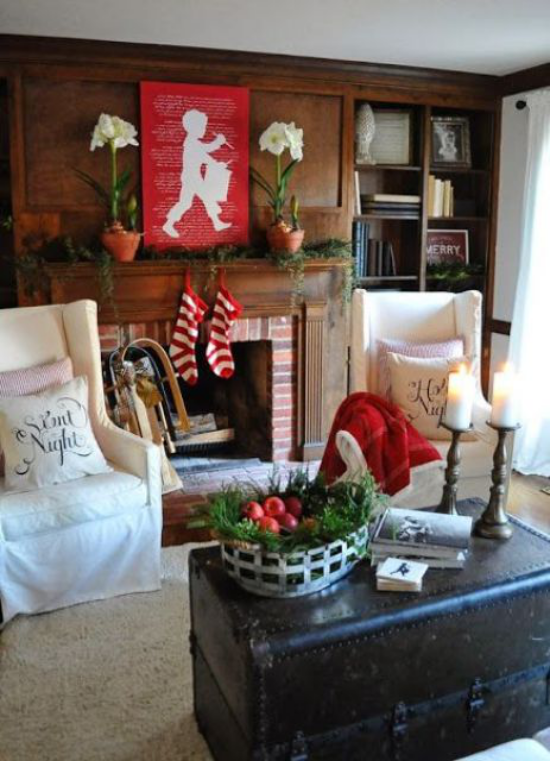 Winterdeko im Wohnzimmer klassische Farbkombination weiß rot grün weißer Sesselbezug natürliches Grün etwas Rot am Kamin