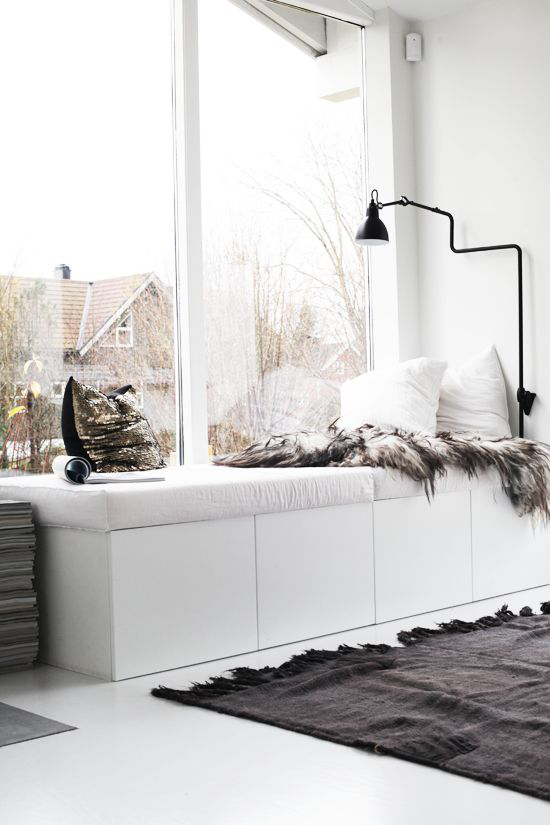  Winterdeko im Wohnzimmer sonnige Fensterecke zum Entspannen Kontrast weiß-schwarz weiche Kissen kuschelige Pelze Teppich
