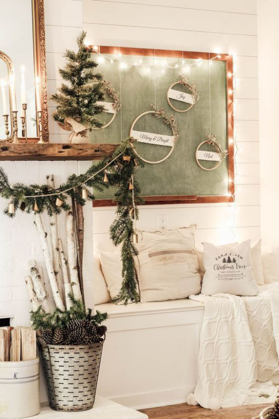 Winterdeko im Wohnzimmer weiße Sitzbank neben dem Kamin toll dekoriert mit einfachen Sachen etwas Grün Tannenzapfen im Eimer