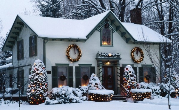 Außenbeleuchtung zu Weihnachten anbringen – 30 festliche Ideen und Tipps weißes haus von schnee bedeckt mit gelben lichtern wenig