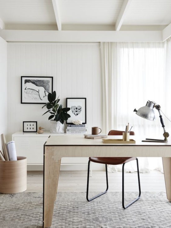Homeoffice in neutralen Farben eleganter Tisch Stuhl Schreibtischlampe angenehme Atmosphäre