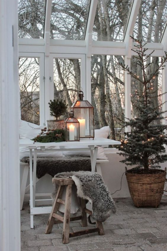 Hygge Feeling zu Weihnachten helles schlichtes Ambiente typisch skandinavisch Laternen weiße Kerzen Lichter Kunstpelz