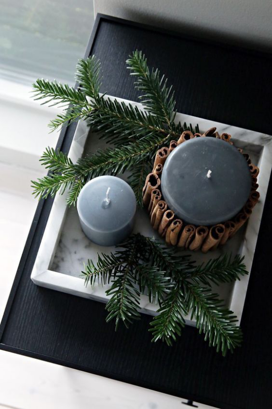 Hygge Feeling zu Weihnachten schönes Arrangement zwei Kerzen Tannenzweige Zimtstangen