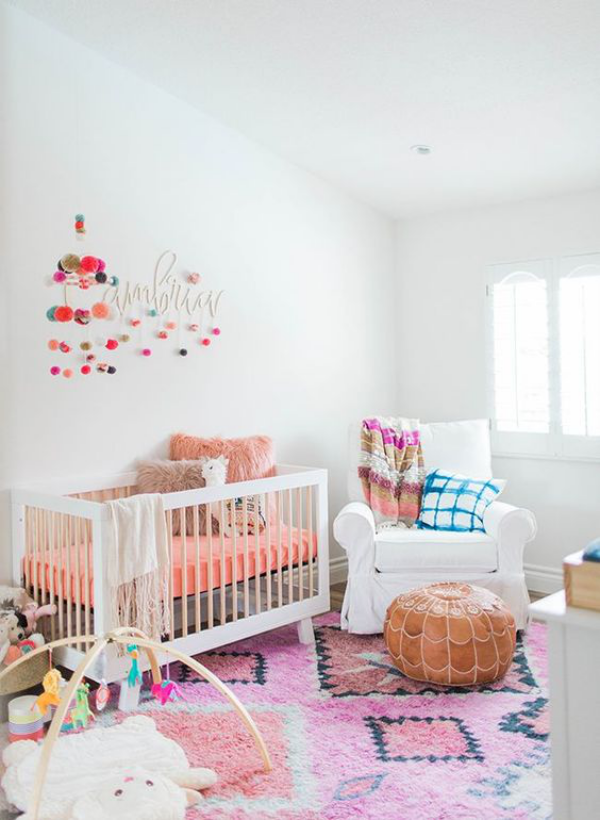 Kunterbuntes Babyzimmer weiße Wände weißes Kinderbett Teppich