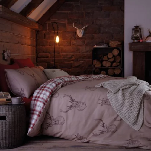 Gemütliches Schlafzimmer im Winter gestalten Brennholz Hängelampe dezentes Licht unter der Dachschräge