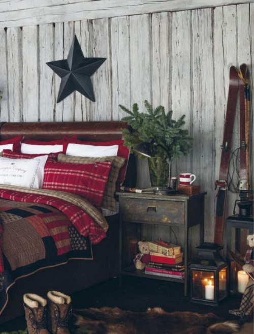 Gemütliches Schlafzimmer im Winter gestalten rustikales Ambiente Stern aus dunklem Holz Holzwand buntes Bettzeug