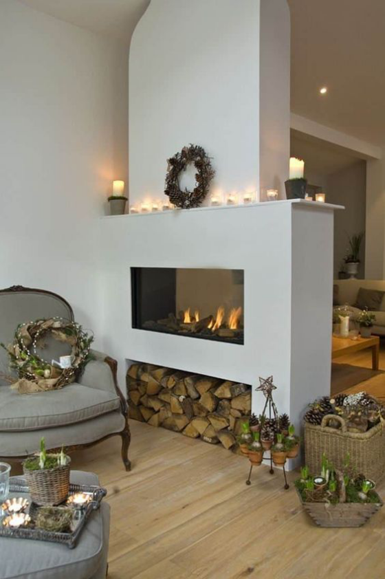 Moderne Kamine rustikales Wohnzimmer doppelseitiger Kamin Brennholz Aufbewahrung Flechtkörbe Blumen Kränze