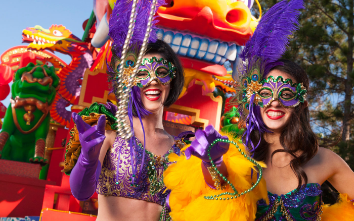 Mardi Gras Karneval feiern auf Amerikansich zwei Frauen verkleidet klassische Farben Violett Goldgelb Grün