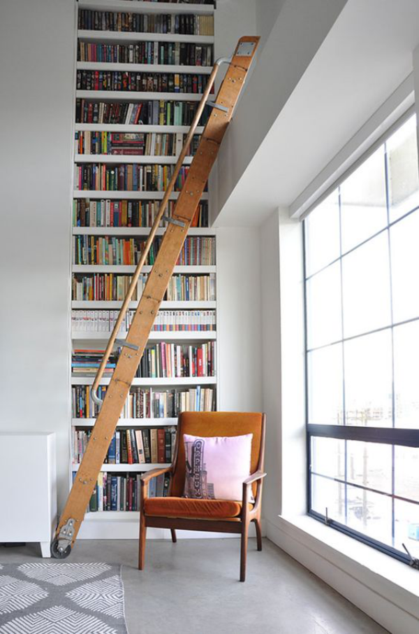 Moderne Hausbibliothek deckenhohe Fenster viel Licht Bücherwand Leiter