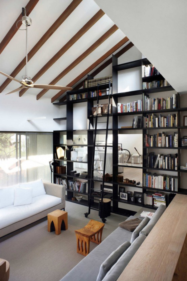 Moderne Hausbibliothek schwarze Bücherregale weiße Möbel Raum unter der Dachschräge